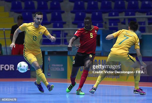 Favito of Mozambique passes the ball between Shervin Keshavarz Adeli and Tobias Seeto of Australia during Group D match play between Mozambique and...