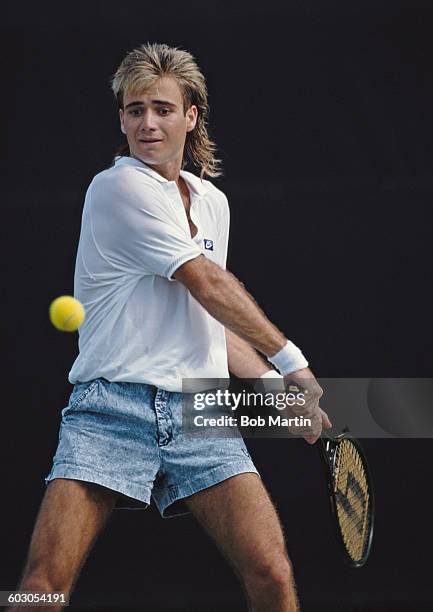 Andre Agassi of the United States wearing his jean style shorts makes a double hand return during a Men's Singles match at the ATP Lipton Tennis...