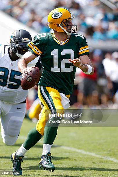 Quarterback Aaron Rogers of the Green Bay Packers is forced out the pocket by Defensive Tackle Abry Jones of the Jacksonville Jaguars during the game...