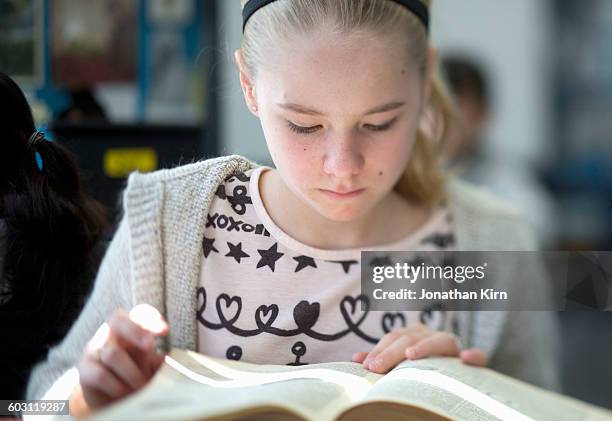 twelve year old girl reads. - 12 year old blonde girl stock-fotos und bilder