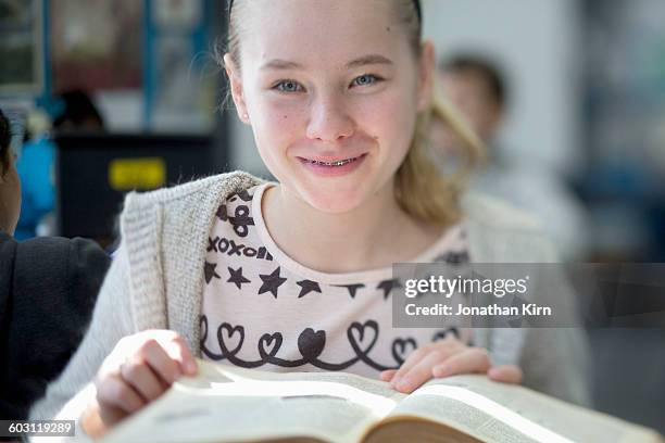 twelve year old girl with a book. - 12 year old blonde girl stock-fotos und bilder