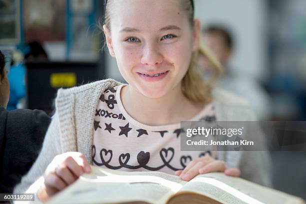 twelve year old girl with a book. - 12 year old blonde girl ストックフォトと画像