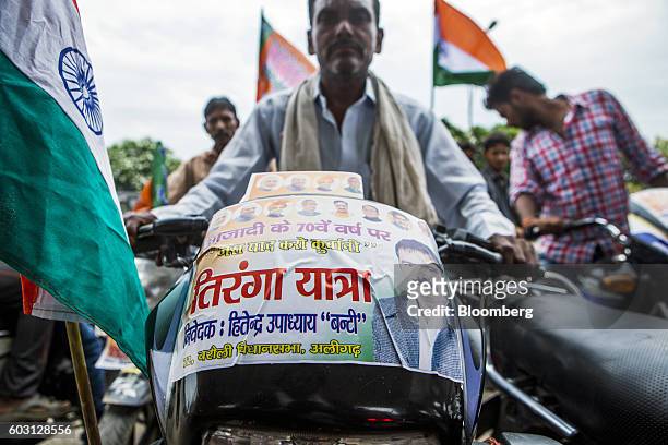 Bharatiya Janata Party members and supporters carry India national flags during a BJP motorcycle party rally near Aligarh, Uttar Pradesh, India, on...