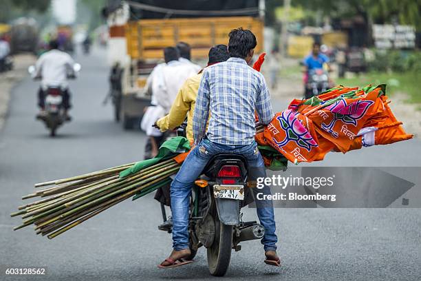 Bharatiya Janata Party members and supporters carry India national flags during a Bharatiya Janata Party motorcycle party rally near Aligarh, Uttar...