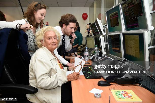 Former French first lady Bernadette Chirac is assisted by traders while making stock market orders, on September 12, 2016 at French investment...