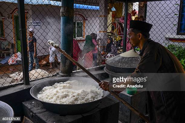 Man makes rice as sacrificial cows were prepared outside the prayer hall during Eid-Al-Adha in Phnom Penh, Cambodia on Monday September 12, 2016.