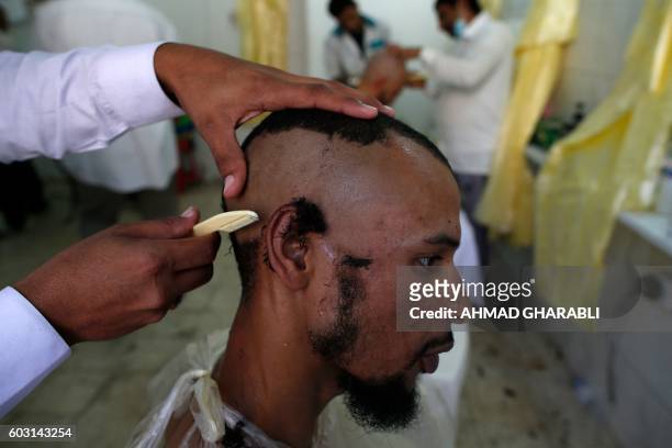 Muslim pilgrims shave their hair after throwing pebbles at pillars during the "Jamarat" ritual, the stoning of Satan, in Mina near the holy city of...