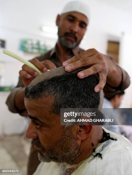 Muslim pilgrim shaves his hair after throwing pebbles at pillars during the "Jamarat" ritual, the stoning of Satan, in Mina near the holy city of...