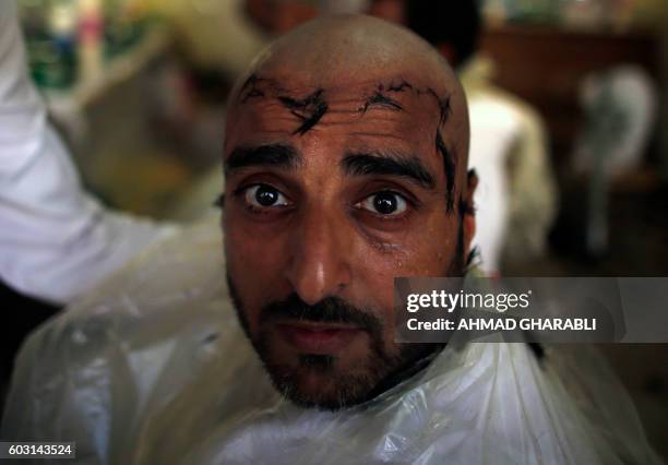 Muslim pilgrim poses for a photo after shaving his hair after throwing pebbles at pillars during the "Jamarat" ritual, the stoning of Satan, in Mina...