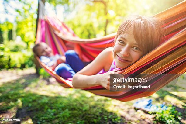 little girl and her brother playing on hammock - garden hammock stock pictures, royalty-free photos & images
