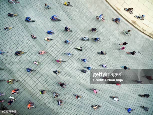 persone in bicicletta per strada - city from above foto e immagini stock