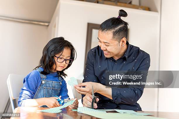 father helping with new project - asian child with new glasses stockfoto's en -beelden