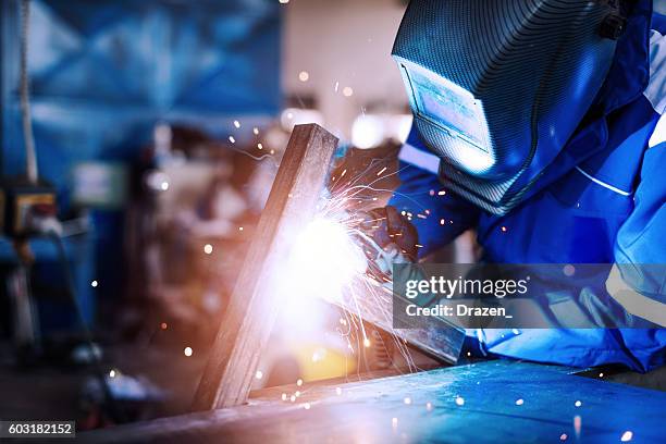 professional welder in a factory welding steel bars - last stockfoto's en -beelden