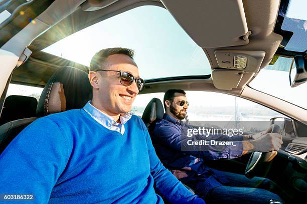reife gleich geschlechtliche paar fahren in luury auto - front passenger seat stock-fotos und bilder