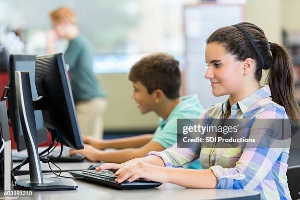 bonne adolescente utilisant un ordinateur dans le laboratoire informatique - computer lab high school with computer screen photos et images de collection