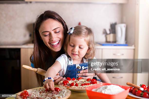 family making pizza together - babysitter stock pictures, royalty-free photos & images