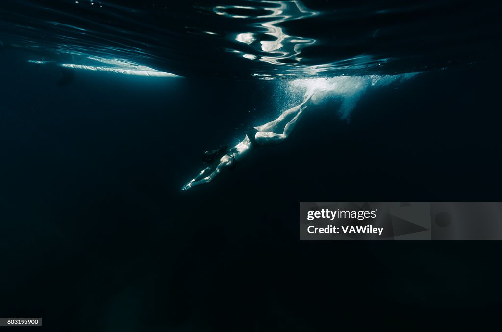 Mujer buceando en aguas oscuras