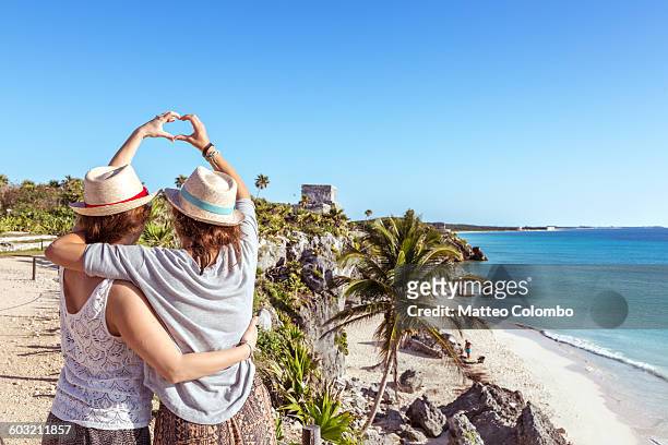 female couple doing a heart sign, tulum, mexico - tulum stock pictures, royalty-free photos & images