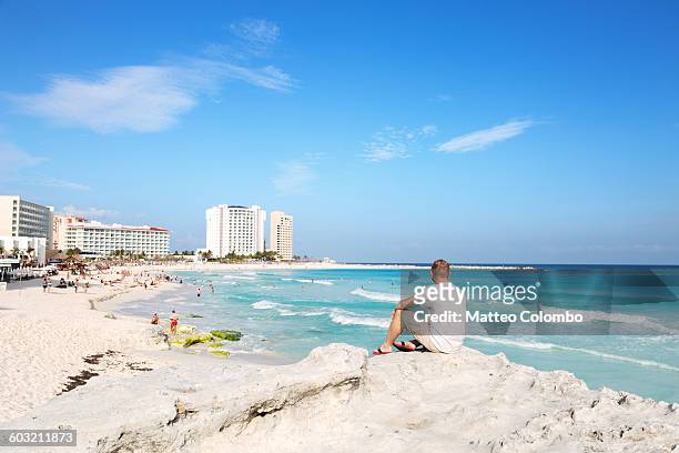 tourist looking at tropical beach, cancun, mexico - resort city stock-fotos und bilder