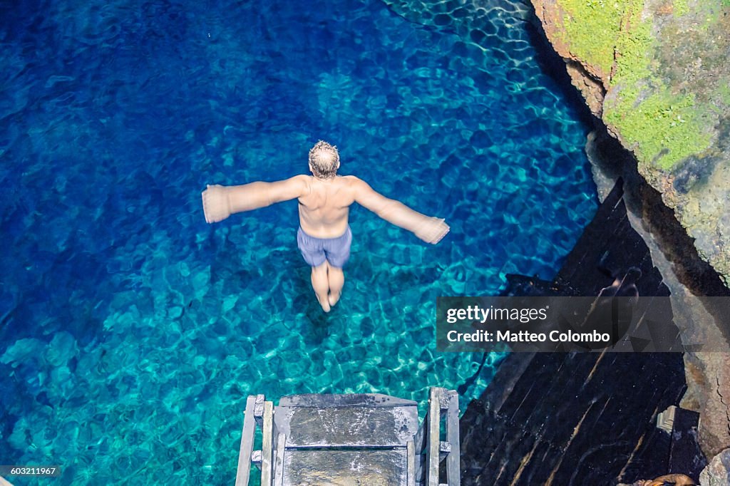 Man diving into a cenote, Yucatan, Mexico