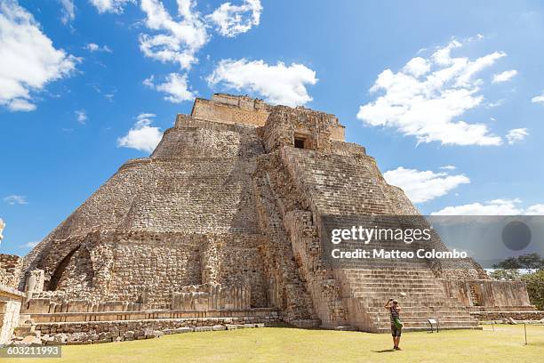 tourist looking at temple, uxmal, mexico - uxmal fotografías e imágenes de stock