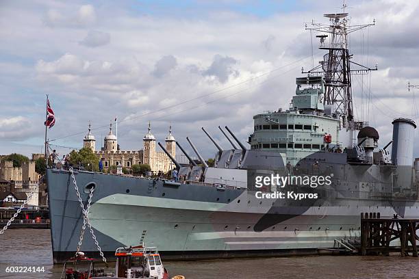 europe, uk, england, london, view of boat - military warship - hms belfast, a royal navy light cruiser, permanently moored in london on the river thames an an exhibit - hms belfast fotografías e imágenes de stock