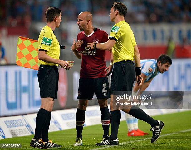 Miso Brecko of Nuernberg discusses with sideline referee Stefan Lupp and referee Bastian Dankert during the Second Bundesliga match between 1. FC...