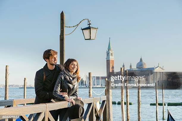 couple embracing on pier in venice lagoon sunset - venice couple foto e immagini stock