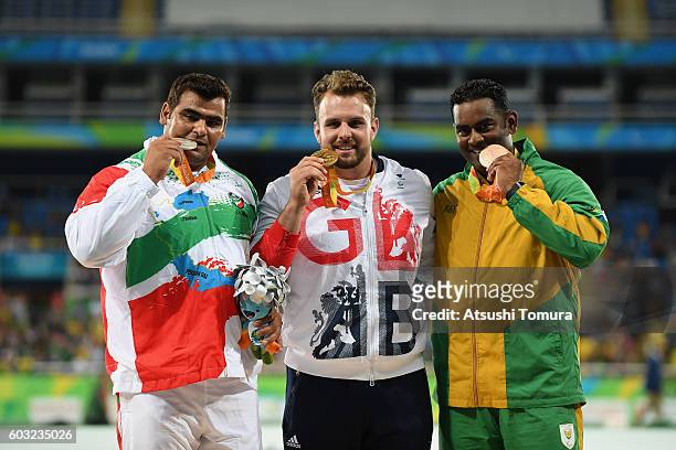 Silver medalist Sajad Mohammadian of Iran, Gold medalist Aled Davies of Great Britain and Bronze medalist Tyrone Pillay of South Africa celebrate on...