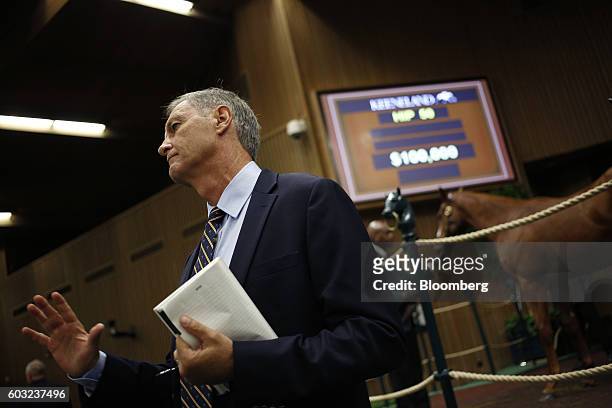 An auction official acknowledges a bid during the 2016 September Yearling Sale at Keeneland Racecourse in Lexington, Kentucky, U.S., on Monday, Sept....