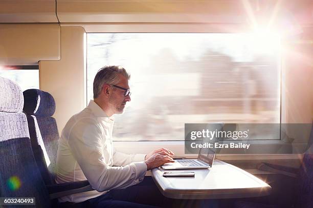 businessman working on a commuter train. - carruagem imagens e fotografias de stock