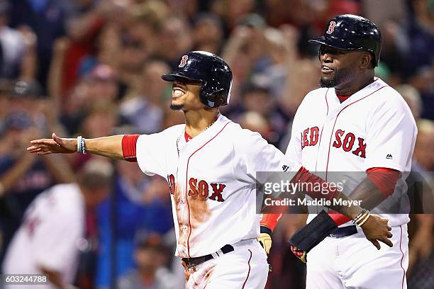 Mookie Betts of the Boston Red Sox and David Ortiz celebrate after scoring runs against the Baltimore Orioles during the first inning at Fenway Park...