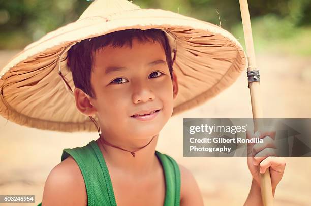 young boy wearing hat, holding bamboo fishing pole - luisiana 個照片及圖片檔