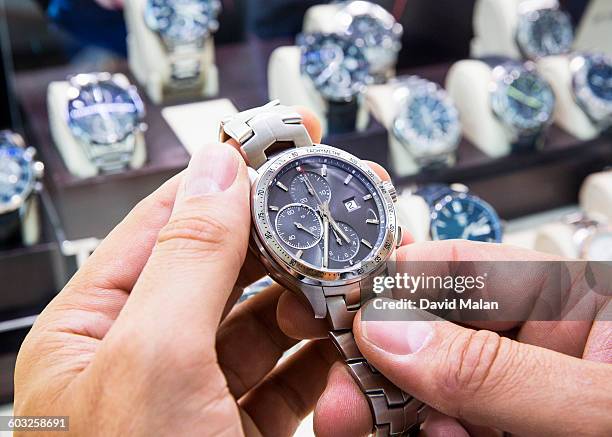 mens wristwatch being held in a watch shop. - 腕時計 ストックフォトと画像