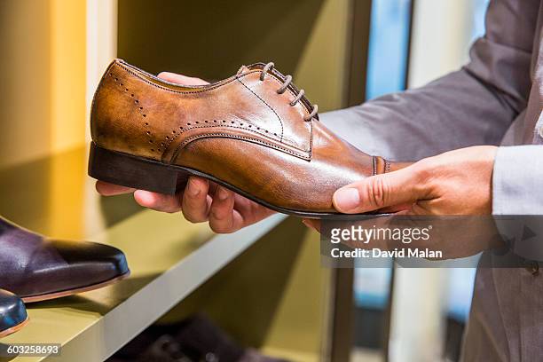 shoe being looked at in an upmarket store. - footwear stock pictures, royalty-free photos & images