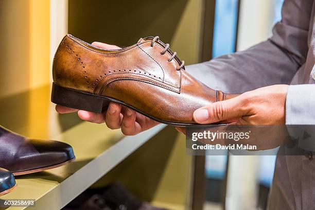 shoe being looked at in an upmarket store. - shoe bildbanksfoton och bilder