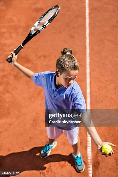 above view of little boy serving a tennis ball. - tennis boy stock pictures, royalty-free photos & images