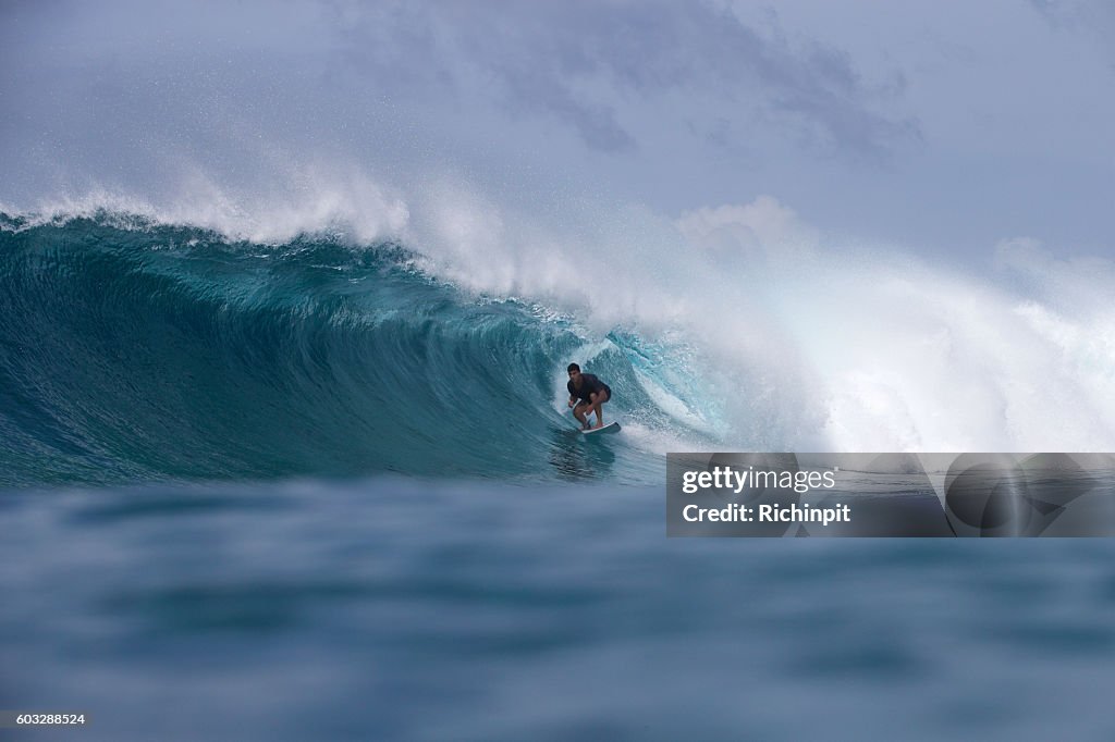 Surfer bekommt ein Fass auf einer großen Welle
