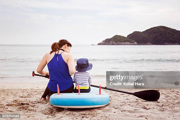 a mother and a baby enjoy water sports in the sea - mother and child in water at beach stock pictures, royalty-free photos & images