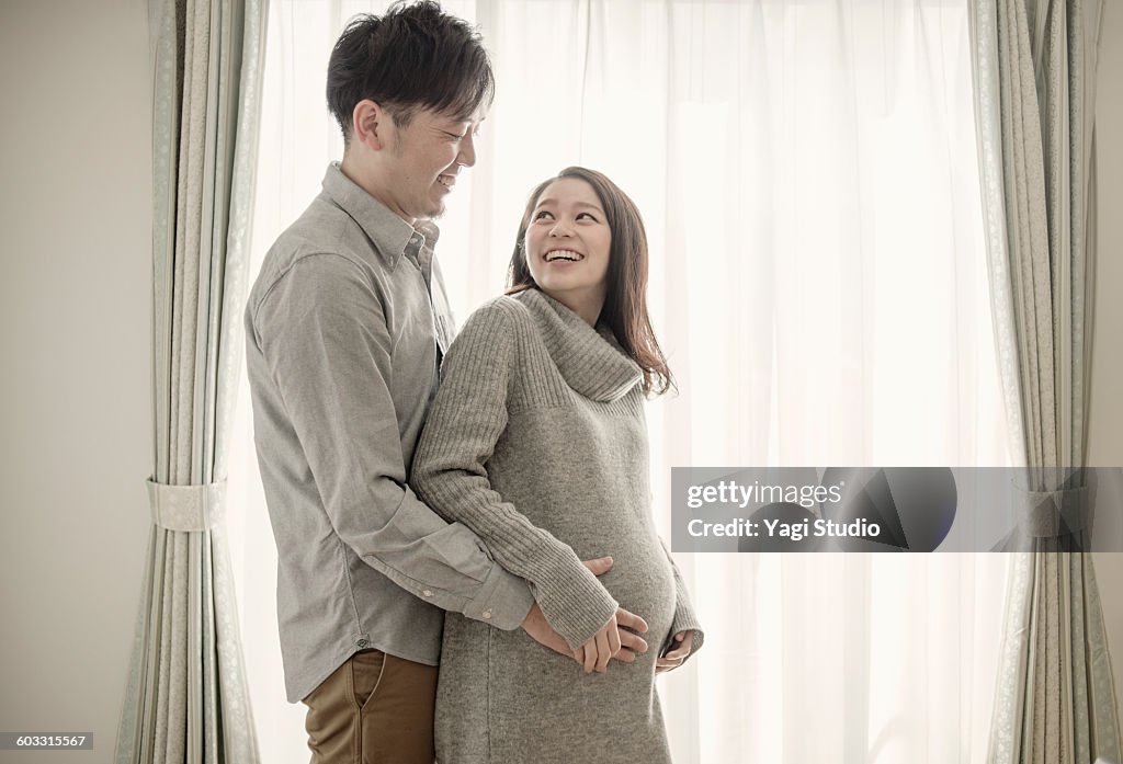Man with hand on pregnant woman's bump