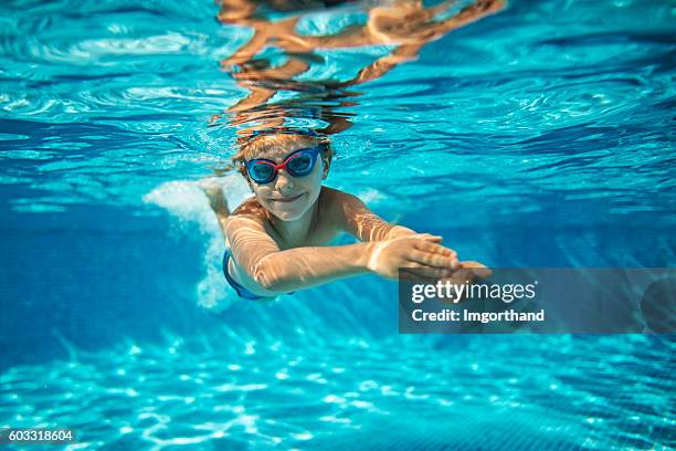 little boy swimming underwater in pool - swimmingpool stock pictures, royalty-free photos & images