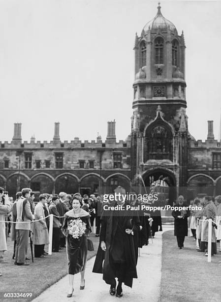 Queen Elizabeth II walks across Tom Quad or the Great Quadrangle with Reverend Cuthbert Simpson, Dean of Christ Church, at Christ Church College,...