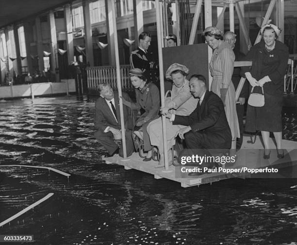 Queen Elizabeth II of Great Britain and Queen Juliana of the Netherlands being shown hydraulic experiments for a planned new harbour entrance for the...