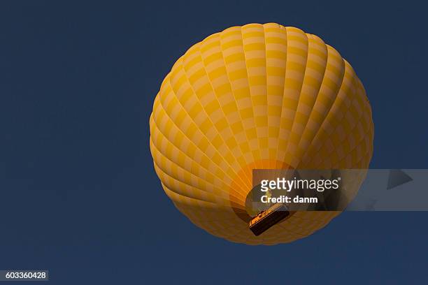 yellow balloon in the blue sky. cappadocia, turkye - hot air balloon ride stock-fotos und bilder