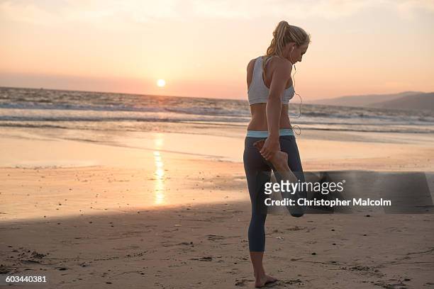 female runner stretches at sunset - woman stretching sunset stock-fotos und bilder