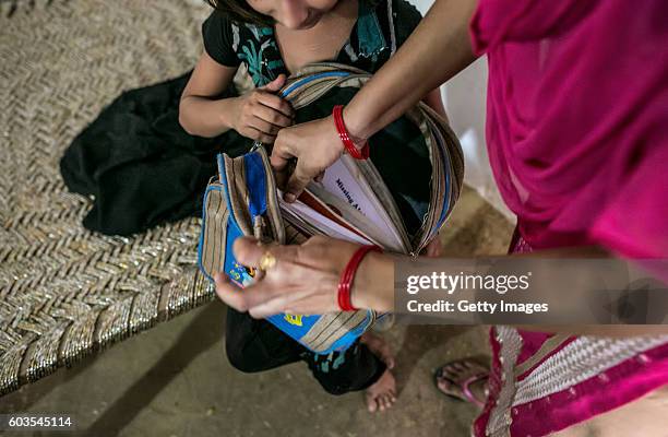 Year old Sadaf and her aunt take out books for her to study on September 8, 2016 in Uttar Pradesh, India. 3 months ago she was raped by a doctor in...