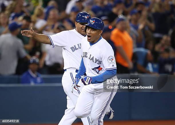 Ezequiel Carrera of the Toronto Blue Jays celebrates as he is congratulated by third base coach Luis Rivera after hitting a pinch-hit solo home run...