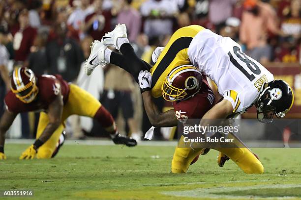 Tight end Jesse James of the Pittsburgh Steelers is tackled by strong safety DeAngelo Hall of the Washington Redskins in the second quarter at...