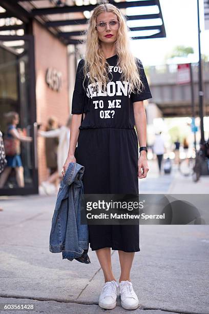 Audi Martel is seen wearing a black t shirt with black skirt and denim jacket with white sneakers while attending Pyer Moss during New York Fashion...