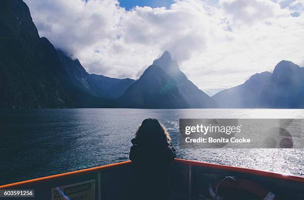 child on a boat, taking a photo of mitre peak, in milford sound - cruise view stock pictures, royalty-free photos & images